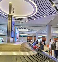 Istanbul, Turkey in July 2022. Tourists picking up their suitcases or luggage on a conveyor belt in the Istanbul international airport. photo