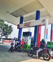 West Java, Indonesia on July 2022. Motorcyclists are queuing to refuel their motorbikes at a gas station. photo