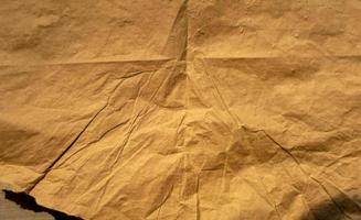 golden old paper with torn and crumpled texture for background photo