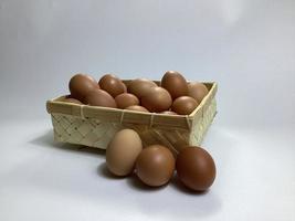 chicken eggs in a bamboo basket on a white background photo