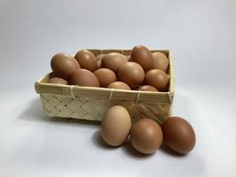 chicken eggs in a bamboo basket on a white background photo