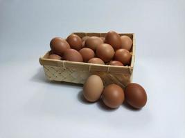 huevos de gallina en una cesta de bambú sobre un fondo blanco foto