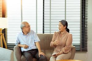 una pareja de ancianos tiene una conversación juntos después de la jubilación, la esposa del esposo tiene una pensión para un momento romántico con una sonrisa feliz, se sientan cerca de la ventana, copian espacio foto