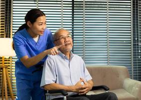 Asian Nurse take care Elderly Senior Man with warm welcome. 70s Mature Man patient has good health and support help by Caregiver from medical hospital. Grandfather sit on wheelchair, copy space photo