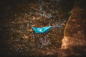 Origami paper boat in the rain photo