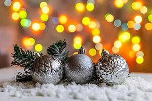 Abstract Advent Christmas Background. Winter decorations ornaments balls on background with snow and defocused garland lights. Merry Christmas time concept. photo