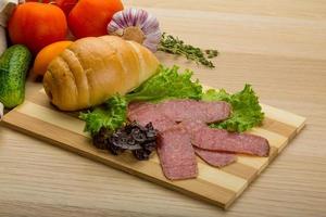 Salami sausages on wooden board and wooden background photo