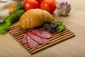 Salami on wooden board and wooden background photo