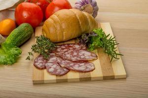 Salami on wooden board and wooden background photo