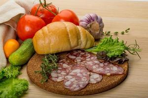 Salami on wooden board and wooden background photo