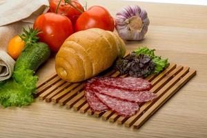 Salami on wooden board and wooden background photo