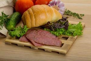 Salami on wooden board and wooden background photo