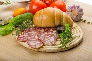 Salami on wooden board and wooden background photo