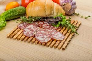 Salami on wooden board and wooden background photo