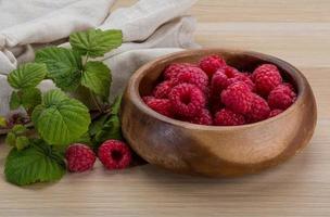 Fresh raspberry in a bowl on wooden background photo