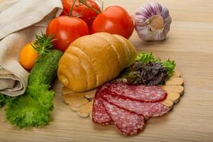Salami on wooden board and wooden background photo