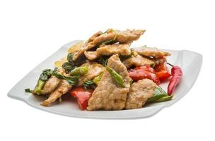 Pork with vegetables on the plate and white background photo