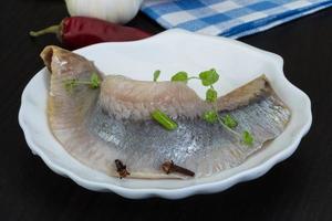 Herring fillet on the plate and wooden background photo