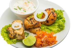 Chicken Tikka on the plate and white background photo