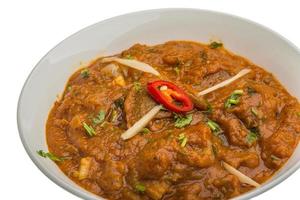 Lamb vindaloo in a bowl on white background photo