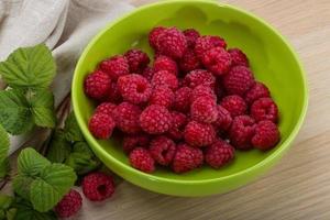 Fresh raspberry in a bowl on wooden background photo