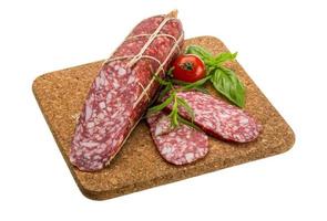 Salami on wooden board and white background photo