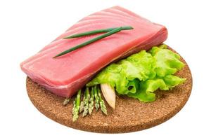 Tuna raw steak on wooden board and white background photo