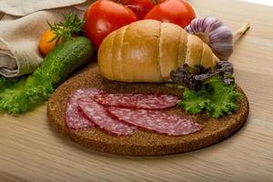 Salami on wooden board and wooden background photo