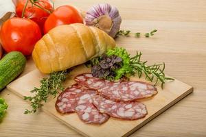 Salami on wooden board and wooden background photo