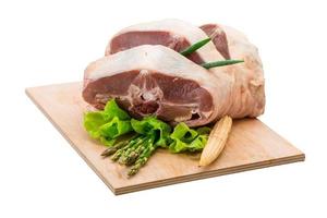 Raw lamb on wooden board and white background photo