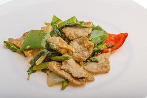 Pork with vegetables on the plate and white background photo