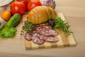 Salami on wooden board and wooden background photo