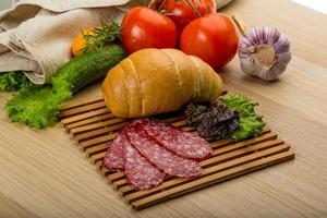 Salami on wooden board and wooden background photo