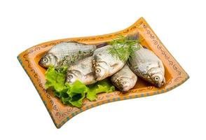 Crucian fish on the plate and white background photo