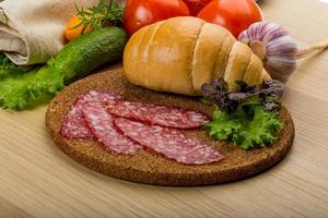 Salami on wooden board and wooden background photo