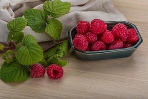 Fresh raspberry in a bowl on wooden background photo