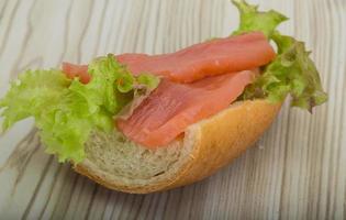 sándwich de salmón sobre fondo de madera foto