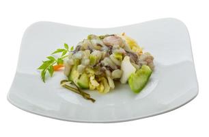 Raw octopus salad on the plate and white background photo