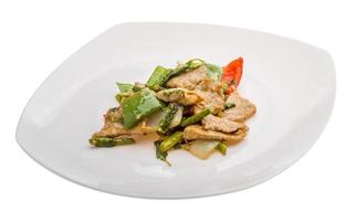 Pork with vegetables on the plate and white background photo