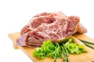 Raw lamb on wooden board and white background photo