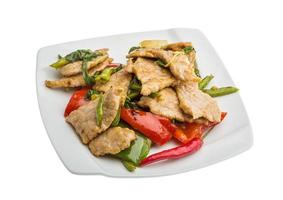 Pork with vegetables on the plate and white background photo