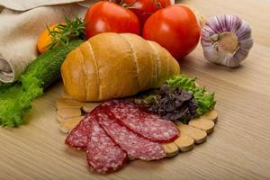 Salami on wooden board and wooden background photo