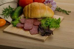 Salami on wooden board and wooden background photo