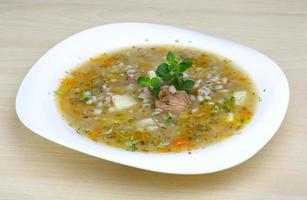 Cereal soup on the plate and wooden background photo