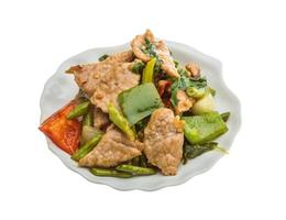 Pork with vegetables on the plate and white background photo