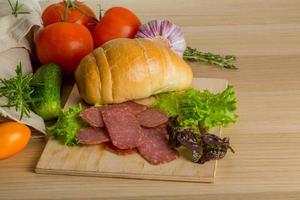 Salami on wooden board and wooden background photo