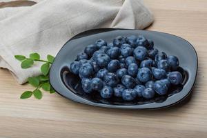 Blueberry on the plate and wooden background photo