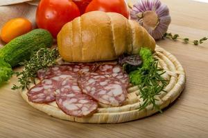 Salami on wooden board and wooden background photo