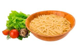 Raw pasta in a bowl on white background photo