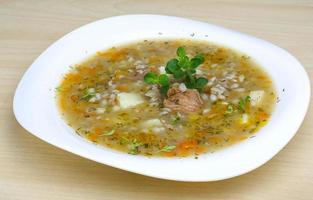 Cereal soup on the plate and wooden background photo